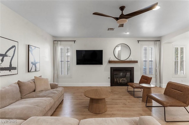 living room featuring light hardwood / wood-style flooring and ceiling fan