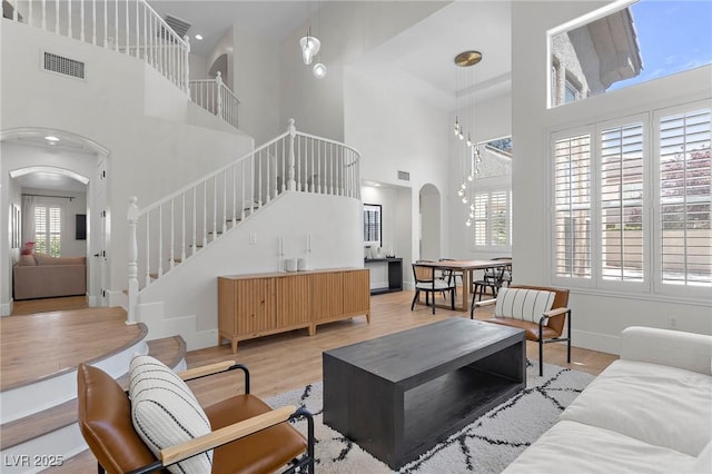 living room with a high ceiling and light wood-type flooring