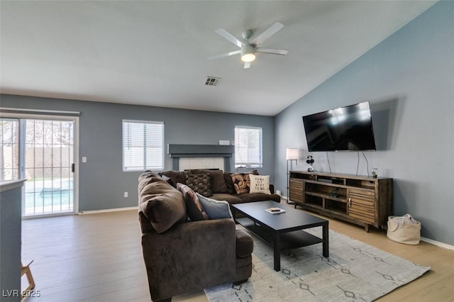 living room with lofted ceiling, hardwood / wood-style floors, and ceiling fan