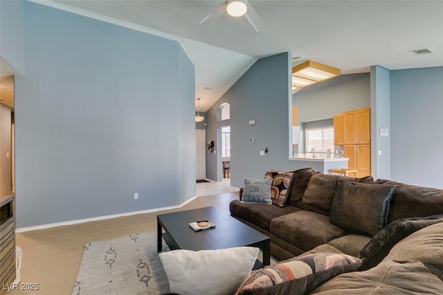 living room with ceiling fan, high vaulted ceiling, and light hardwood / wood-style floors