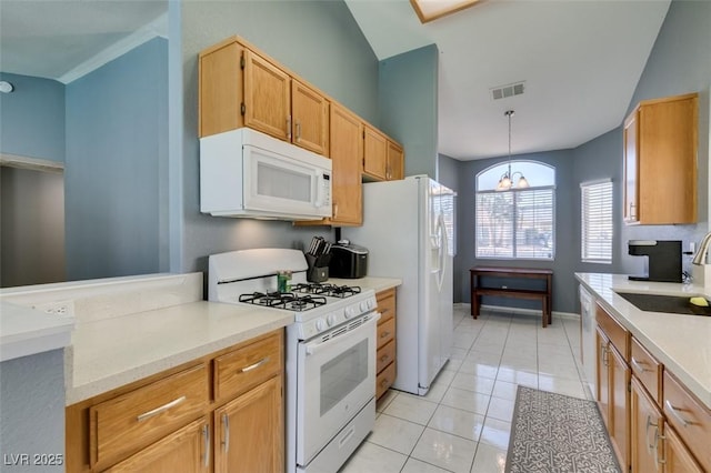 kitchen featuring sink, hanging light fixtures, light tile patterned floors, a notable chandelier, and white appliances