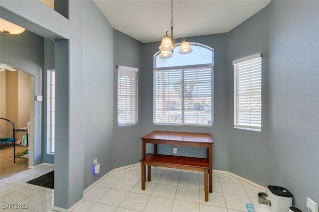 tiled dining room featuring a chandelier