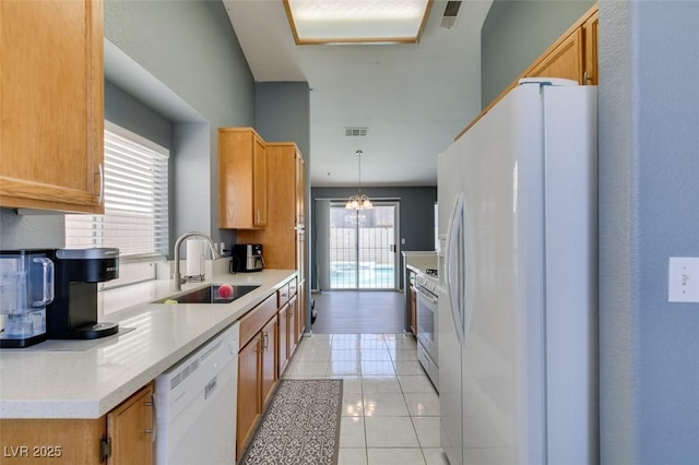 kitchen featuring sink, white appliances, decorative light fixtures, and light tile patterned flooring