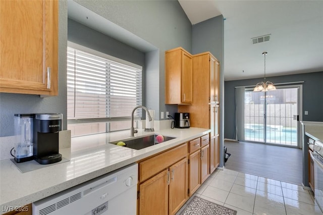 kitchen featuring decorative light fixtures, dishwasher, sink, light stone countertops, and an inviting chandelier