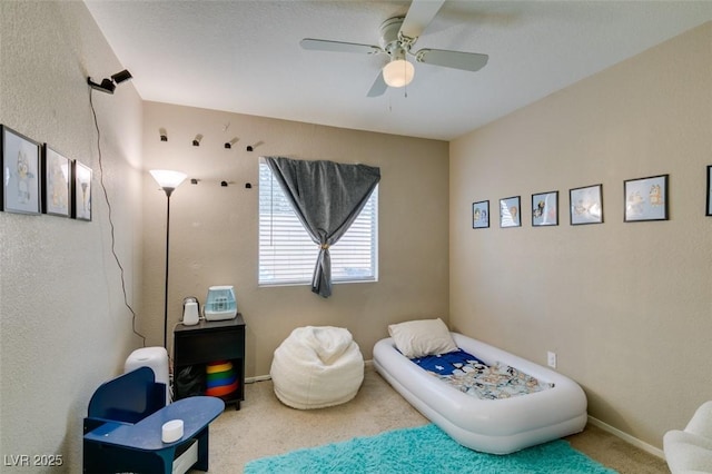 sitting room featuring carpet and ceiling fan