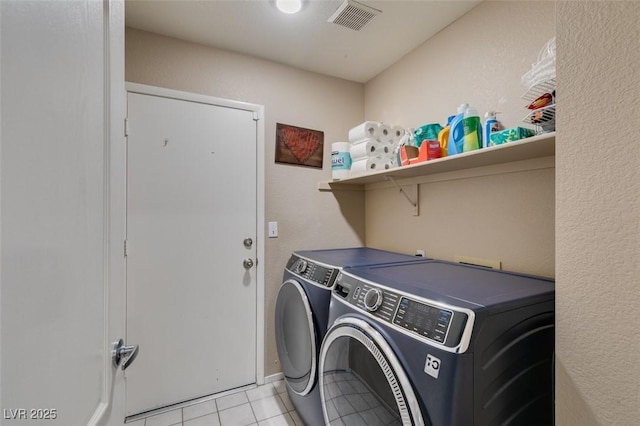 laundry room with light tile patterned floors and washer and clothes dryer