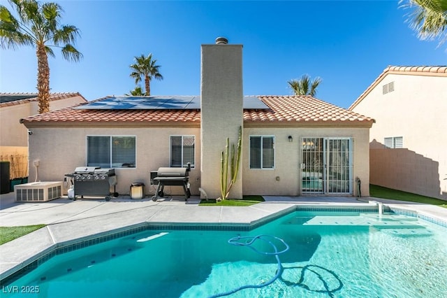 rear view of house featuring a patio and solar panels