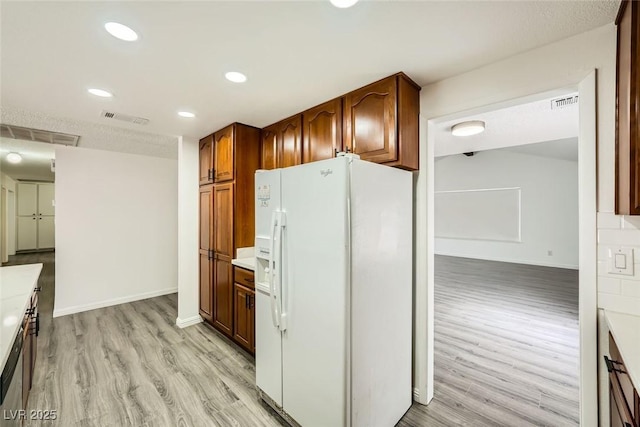 kitchen with light wood-type flooring and white fridge with ice dispenser