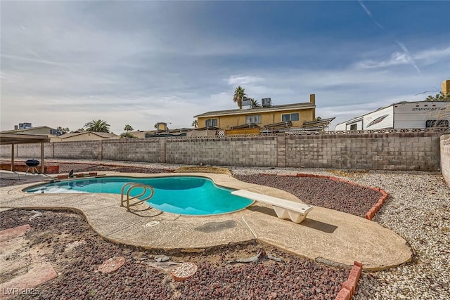 view of pool featuring a patio area and a diving board