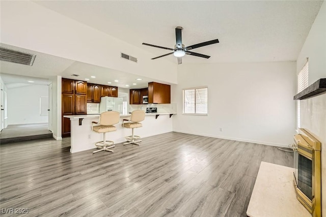 unfurnished living room featuring high vaulted ceiling, ceiling fan, and light hardwood / wood-style flooring