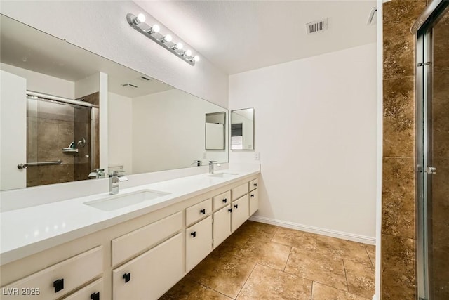 bathroom with a shower with door, vanity, and tile patterned floors