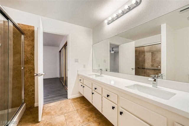 bathroom featuring ceiling fan, vanity, an enclosed shower, and tile patterned flooring