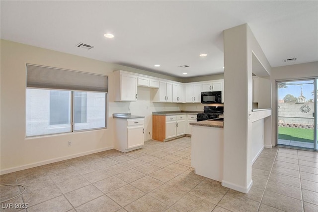 kitchen with white cabinetry, range, and light tile patterned floors