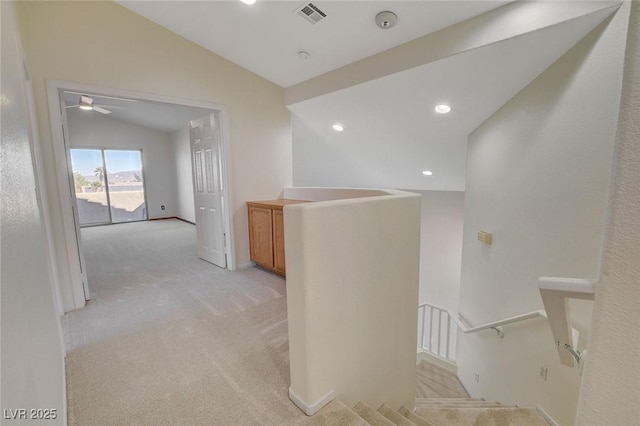 hall featuring vaulted ceiling and light colored carpet