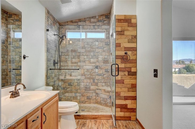 bathroom with lofted ceiling, vanity, wood-type flooring, toilet, and walk in shower