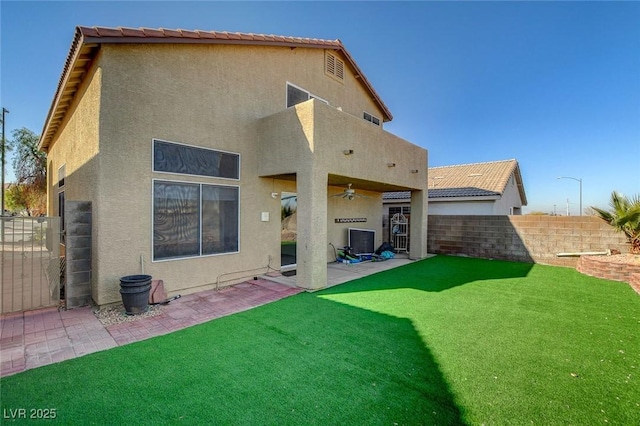 back of house with ceiling fan, a yard, and a patio area