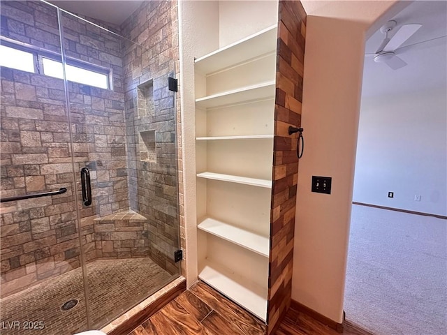 bathroom with ceiling fan and a shower with door