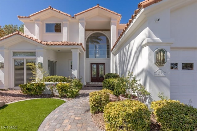 view of front of house with a garage and french doors