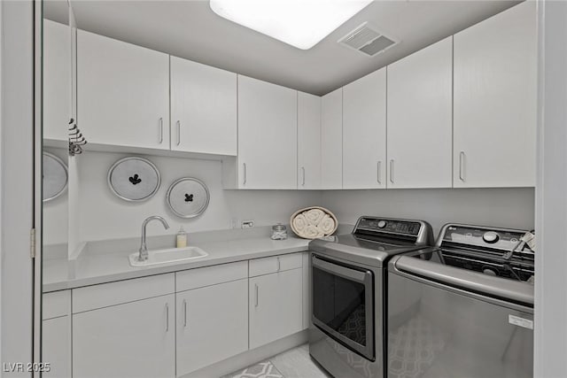 laundry room featuring cabinets, independent washer and dryer, and sink