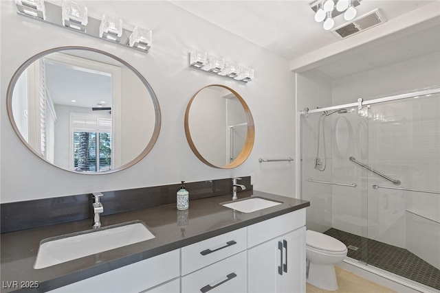 bathroom with walk in shower, vanity, and toilet