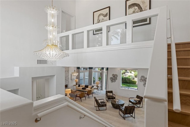 living room with a high ceiling, hardwood / wood-style floors, and a notable chandelier