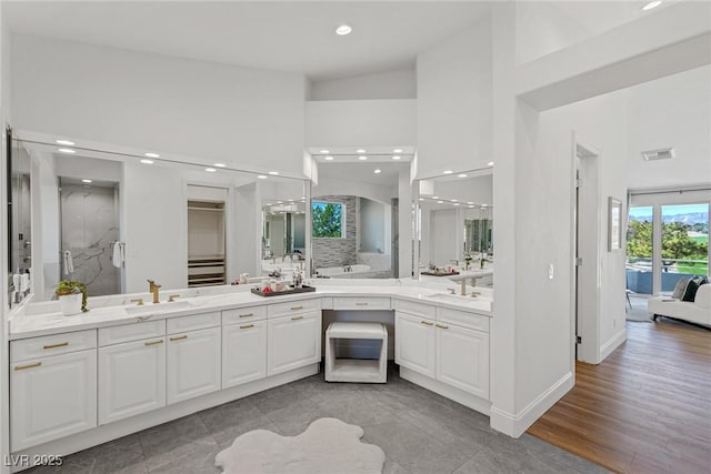 bathroom featuring vanity, hardwood / wood-style flooring, high vaulted ceiling, and walk in shower