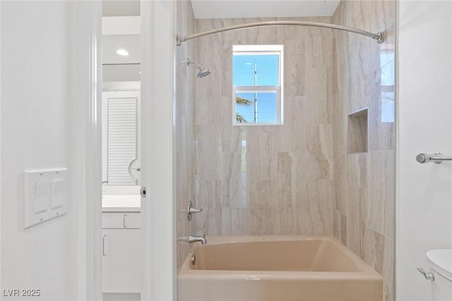 full bathroom featuring vanity, tiled shower / bath combo, and toilet