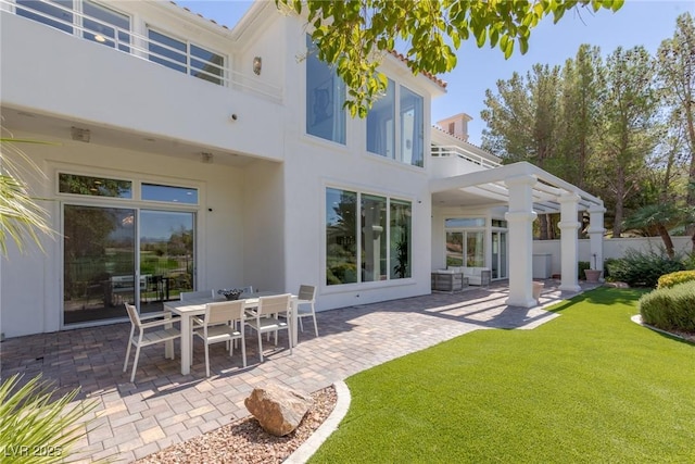 rear view of property with a yard, a pergola, and a patio area