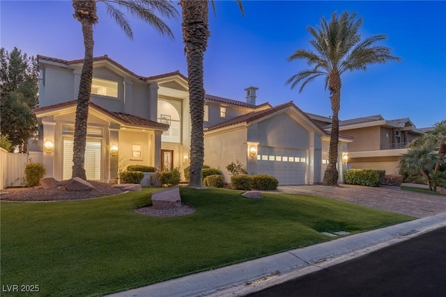 mediterranean / spanish-style house with a garage and a lawn