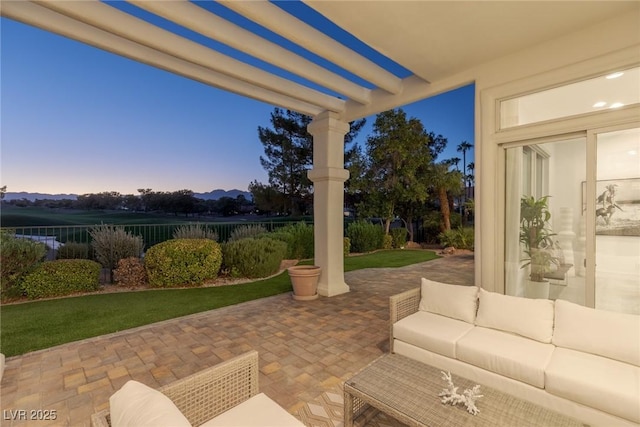 patio terrace at dusk featuring a pergola and outdoor lounge area