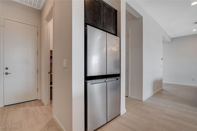 kitchen featuring dark brown cabinetry and stainless steel refrigerator