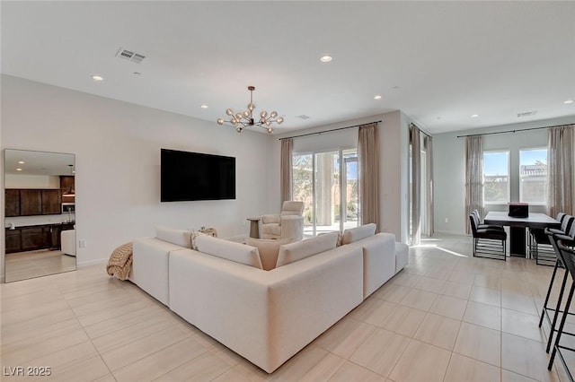 living room featuring a notable chandelier, light tile patterned floors, and a healthy amount of sunlight