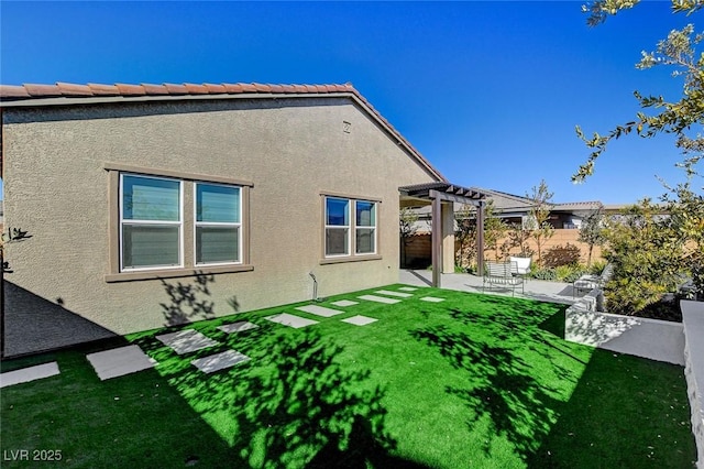 rear view of house with a pergola, a patio, and a lawn