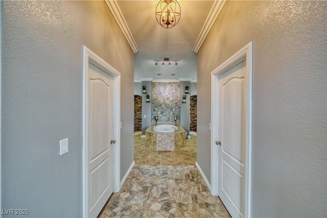 hallway with ornamental molding and a notable chandelier