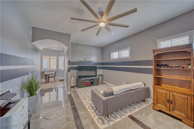 living room featuring a wealth of natural light and ceiling fan