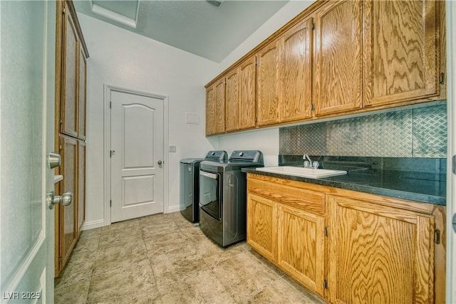 laundry room featuring cabinets, separate washer and dryer, and sink