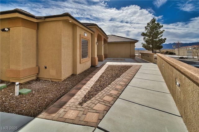 view of side of home featuring a mountain view and a patio area