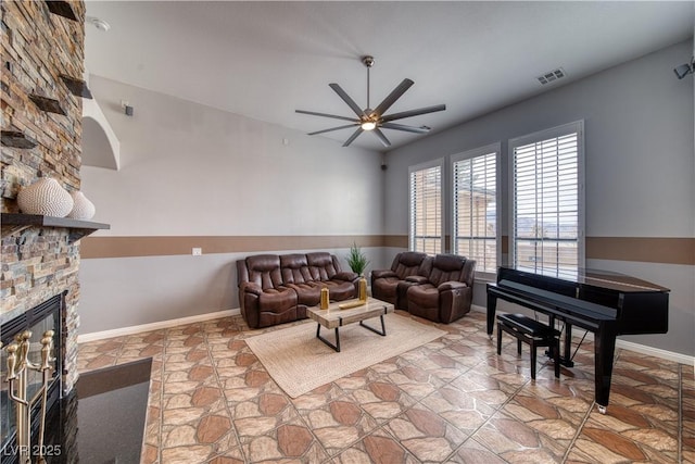 living room featuring ceiling fan and a fireplace