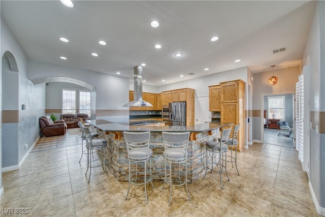 kitchen with a spacious island, stainless steel appliances, a wealth of natural light, and island range hood