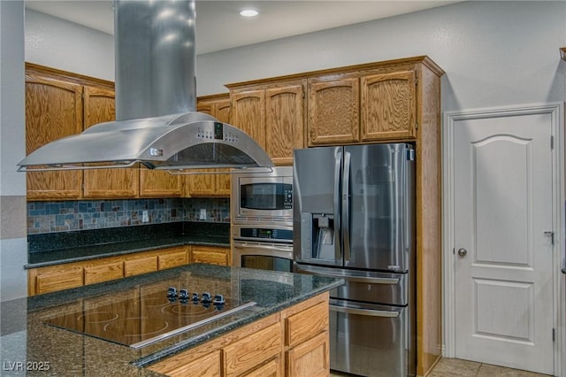 kitchen with tasteful backsplash, island range hood, stainless steel appliances, and dark stone counters