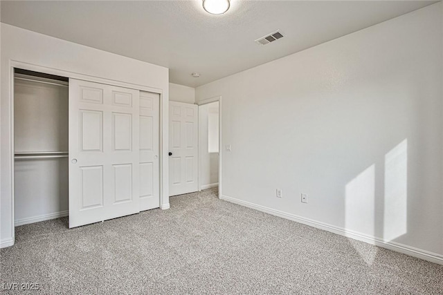 unfurnished bedroom with carpet floors, a closet, and a textured ceiling