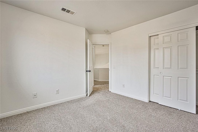 unfurnished bedroom featuring light colored carpet and a closet