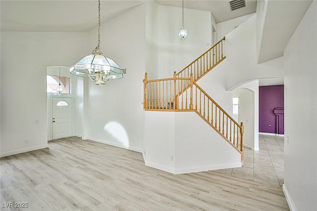 foyer with high vaulted ceiling and light hardwood / wood-style flooring