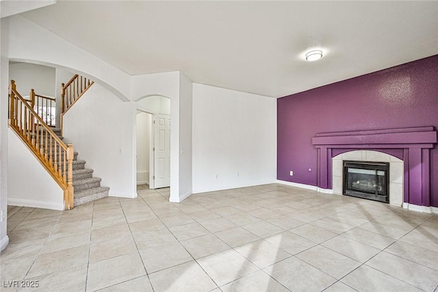 unfurnished living room with a tile fireplace and light tile patterned floors