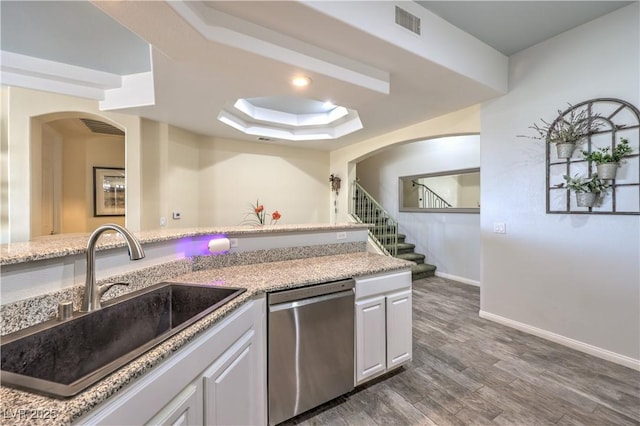 kitchen featuring sink, white cabinets, stainless steel dishwasher, a tray ceiling, and dark wood-type flooring