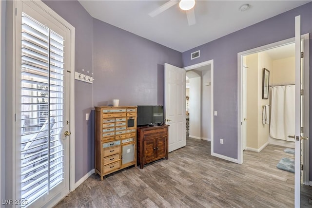 home office with hardwood / wood-style flooring and ceiling fan