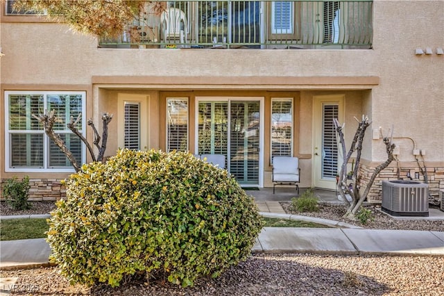 property entrance featuring a balcony and central air condition unit