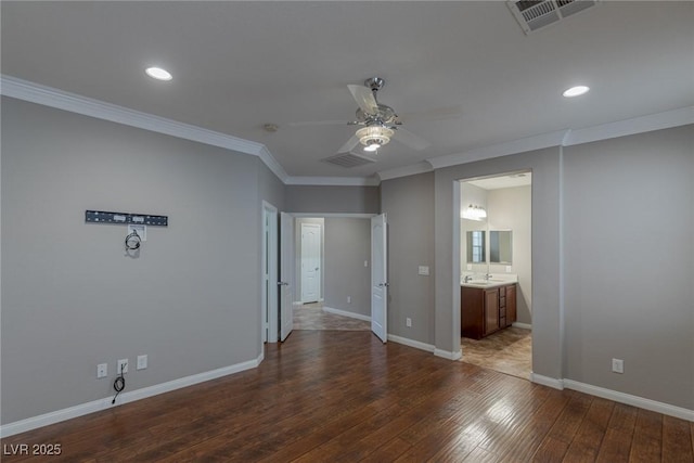 empty room with sink, dark wood-type flooring, and ornamental molding