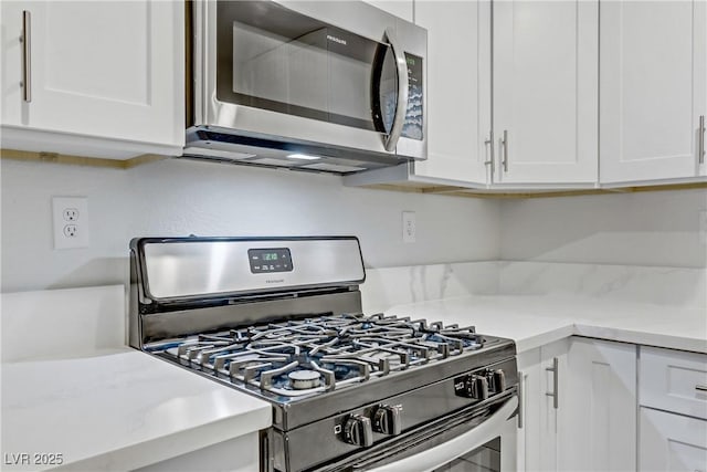 kitchen featuring stainless steel appliances and white cabinetry