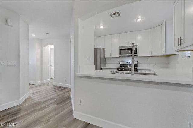 kitchen featuring white cabinetry, appliances with stainless steel finishes, sink, and light hardwood / wood-style floors